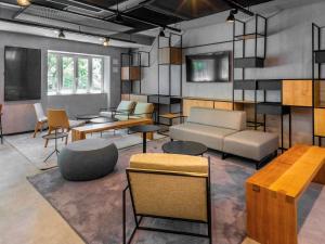 a living room with a couch and tables and chairs at ibis Porto Centro Mercado Bolhao in Porto