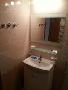 W łazience znajduje się umywalka i lustro. w obiekcie Апартмент Blue Sky w Swetim Własie
