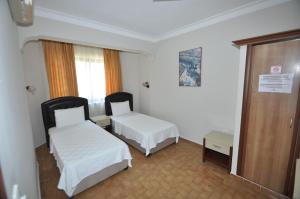 Postel nebo postele na pokoji v ubytování Defne & Zevkim Hotel