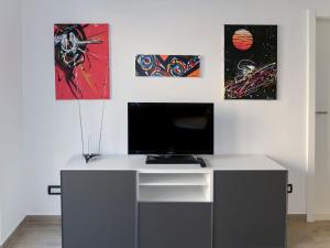 einen Schreibtisch mit einem TV und einige Gemälde an der Wand in der Unterkunft Apartment Bacic - OMI216 by Interhome in Marusici 