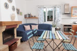 sala de estar con sofá azul y chimenea en Nagymajor Birding Lodge en Tiszacsege