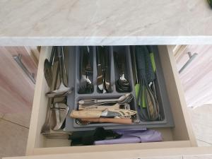 a drawer filled with lots of utensils at Adventure apartamentai in Druskininkai