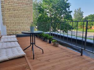 a patio with a table and a bench on a balcony at Adventure apartamentai in Druskininkai