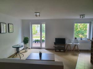 een woonkamer met een bank en een tafel en stoelen bij Adventure apartamentai in Druskininkai