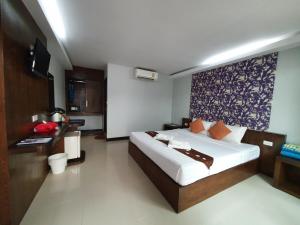 
a hotel room with a bed, desk and a lamp at Ibiza House Phi Phi in Phi Phi Islands
