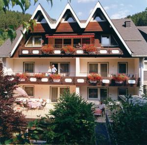 ein Gebäude mit Menschen auf den Balkonen in der Unterkunft Aparthotel Jägerhaus in Willingen