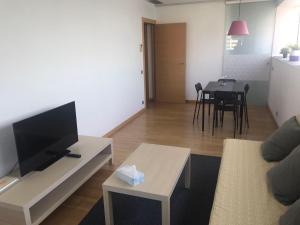 a living room with a couch and a tv and a table at Sotell Apartment Gran Via Europa BCN in Las Corts