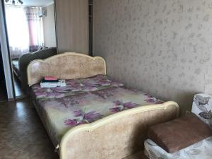 a bedroom with a bed with a floral bedspread at Apartment Erofey Arena at Morozova 87 in Khabarovsk