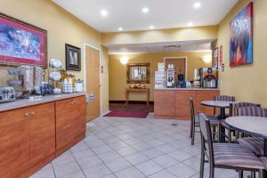 a restaurant with tables and chairs and a kitchen at Econo Lodge Louisville Airport in Louisville