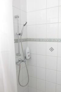 La salle de bains est pourvue d'une douche et de carrelage blanc. dans l'établissement Nagymajor Birding Lodge, à Tiszacsege