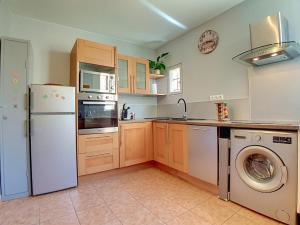a kitchen with a white refrigerator and a dishwasher at Stop Chez M Cozy # Qualité # Confort # Simplicité in Pierre-Bénite