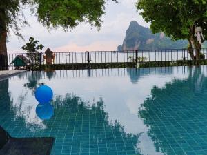 
people are swimming in a pool with blue umbrellas at Ibiza House Phi Phi in Phi Phi Islands
