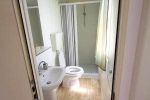 La salle de bains blanche est pourvue de toilettes et d'un lavabo. dans l'établissement Apartments Pipi, à Pakoštane