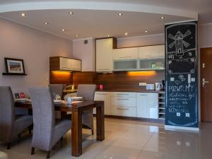 a kitchen with a table and chairs and a chalkboard at VacationClub – Platan 4B Apartament 2 in Świnoujście
