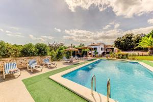 a swimming pool with chairs and a house at Villa Salve in Pollença