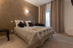 um quarto com uma cama e uma grande janela em Hotel Alizéa em Avignon