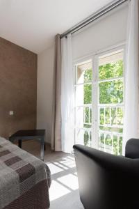 a bedroom with a bed and a large window at Hotel Alizéa in Avignon