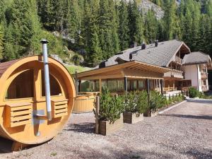 a building with a large wooden object in front of it at Hotel Villetta Maria Cottage in Canazei