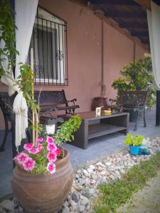 a porch with a bench and flowers in front of a house at Elaias Gea -Kalampaka in Kalabaka