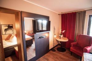 a hotel room with a small table and a bedroom at Burghotel Pass in Südlohn