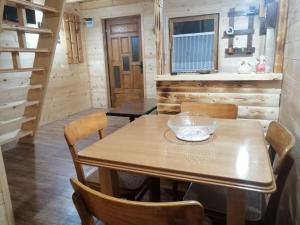 a dining room with a wooden table and chairs at Brvnara Fruska Koliba in Vrdnik