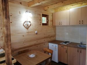 a kitchen with a wooden wall with a wooden table at Brvnara Fruska Koliba in Vrdnik