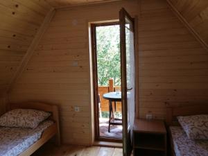 a room with two beds and a window in a cabin at Brvnara Fruska Koliba in Vrdnik