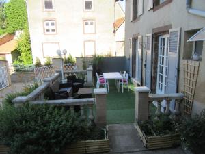 a patio with a table and chairs and a building at La belle endormie - appartement B in Fénétrange