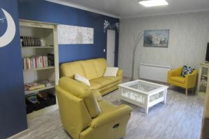 La belle endormie - appartement B في Fénétrange: غرفة معيشة مع أريكة صفراء وكرسيين