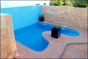 a swimming pool with a brick wall and blue water at Chalet 2 dormitorios con piscina privada in Conil de la Frontera