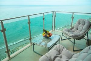 a balcony with two chairs and a table and the ocean at Aqua Batumi Hotel & Apartments in Batumi