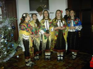 eine Gruppe von Mädchen steht vor einem Weihnachtsbaum in der Unterkunft Pension Anastasia in Gura Humorului