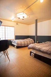 um quarto com duas camas e uma cadeira em Otaru Village - Vacation STAY 84437 em Otaru