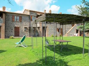 a picnic table and chairs in front of a house at Apartment Pomele-1 by Interhome in San Lorenzo Nuovo