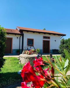 a house with red flowers in front of a yard at Il Melograno in Francavilla Marittima