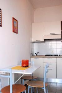 a kitchen with white cabinets and a table and chairs at Apartment Il Seccione-1 by Interhome in Portoferraio