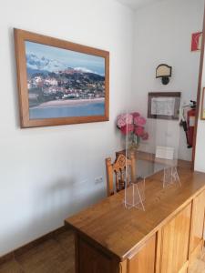 uma mesa de jantar com uma fotografia na parede em Pension Villa ** em Comillas