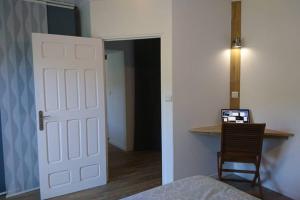 a bedroom with a white door and a desk with a laptop at Gîte de charme en Ardèche : vue panoramique, plage privée in Saint-Fortunat-sur-Eyrieux