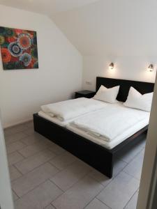 ein Bett in einem Schlafzimmer mit einem Bild an der Wand in der Unterkunft Ferienwohnung Weißburgunder in Lieser