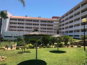 a large building with two umbrellas in the grass at Casa del Sol in Manilva