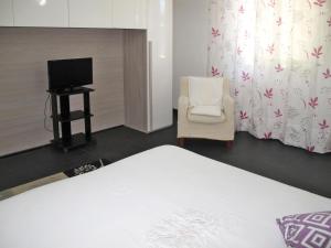 マリーナ・ディ・マッサにあるHoliday Home Pucci by Interhomeのベッドルーム(ベッド1台、椅子、テレビ付)
