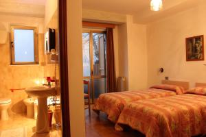 una camera d'albergo con due letti e un bagno di Albergo Ristorante Montecucco da Tobia a Sigillo