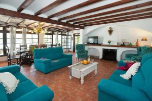 ein Wohnzimmer mit blauen Sofas und einem Kamin in der Unterkunft Villa Tomeu in Port de Pollença