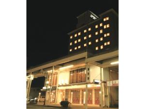 um edifício alto com luzes acesas à noite em Mizusawa Ground Hotel - Vacation STAY 84949 em Oshu