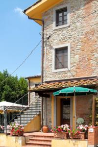 a building with an umbrella in front of it at Apartment I Colletti - App- Luna by Interhome in San Piero in Campo