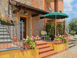 a house with a porch with flowers and an umbrella at Apartment I Colletti - App- Luna by Interhome in San Piero in Campo