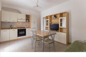 a kitchen and dining room with a table and chairs at Villino Sporting in Lido di Spina
