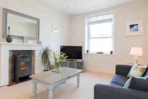 a living room with a fireplace and a tv at The Loft in St Ives