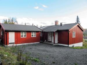 zwei rot-weiße Gebäude in einem Hof in der Unterkunft Chalet Skeisvegen - OPP208 by Interhome in Svingvoll