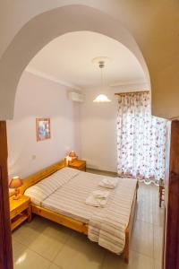 a bedroom with a large bed and a window at Filoxenia Apartments 2 in Palaiochora